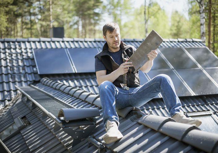 mężczyzna siedzący na dachu